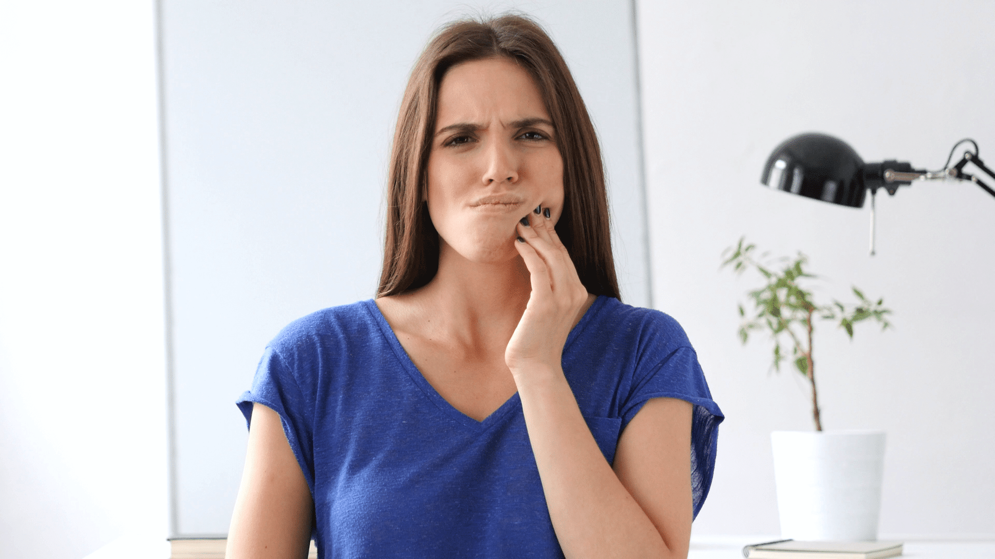 Woman touching her jaw in pain