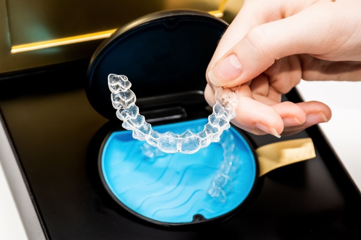 Patient holding Invisalign tray during orthodontic treatment