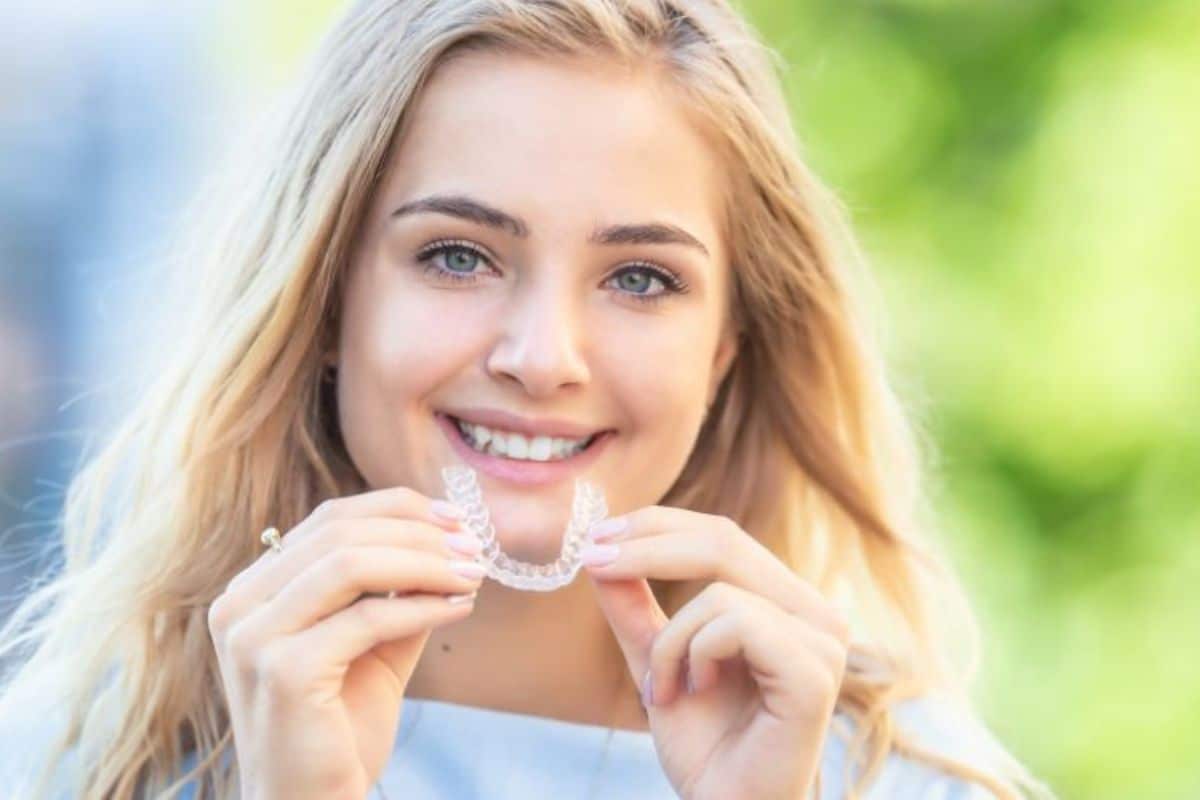 Woman showing Invisalign aligners